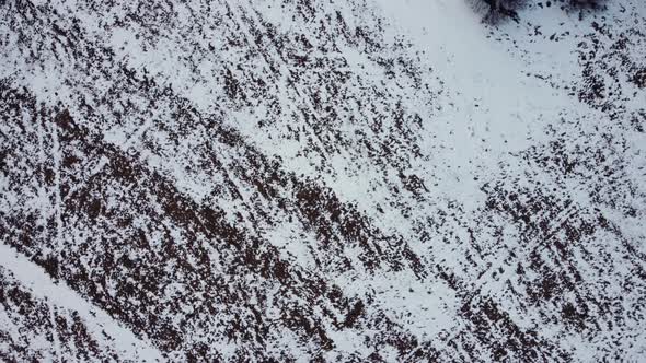 Snow-covered plowed field in winter. abstract drawings. Arable land aerial view.