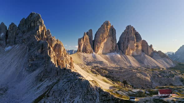 Stunning mountain shelter above Tre Cime at sunset, aerial view alt