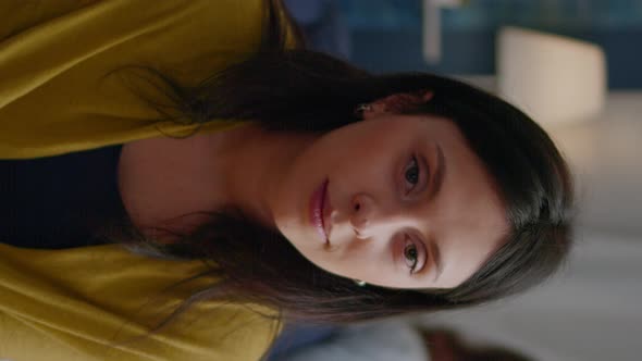 Vertical Video Close Up of Beautiful Woman Looking Into Camera While Sitting on Sofa During Night alt