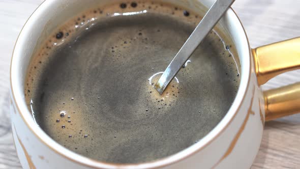 Pieces Of Instant Coffee Fall From The Spoon Into the Cup