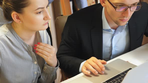 Group of Young Colleagues Comparing Sales Result Graph on Paper with Chart on Computer Screen at alt