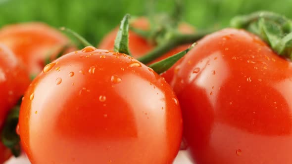 Cherry tomatoes close-up. Rotating on a green background Macro shot. Garden, gardening concept. alt