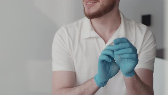 The dentist puts on medical gloves and prepares for the patient's treatment. 