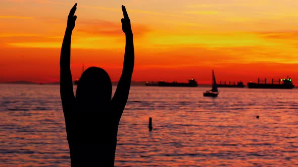 Woman performing yoga on the beach alt