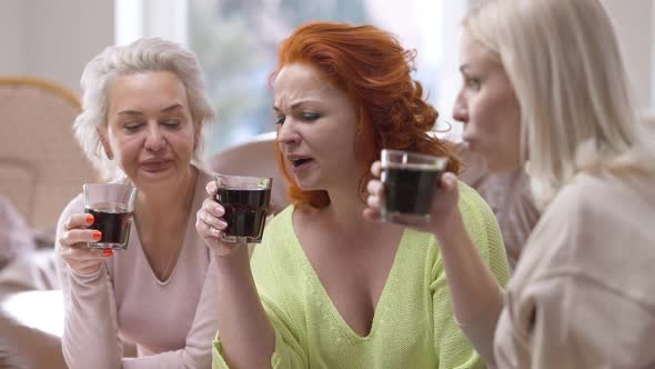 Three Charming Attractive Slim Women Drinking Soda Water Talking Sitting Indoors alt