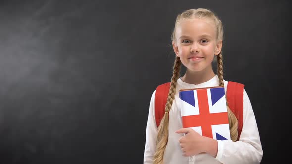 Smiling Female Pupil Holding Textbook With Printed Great Britain Flag, Languages alt