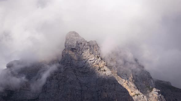 Timelapse of Clouds passing over a rocky mountain outcrop alt