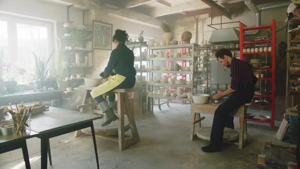 Man and Woman Are Working On Pottery Wheels