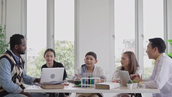 Teacher teaching and explaining chemistry experiment in science classroom alt