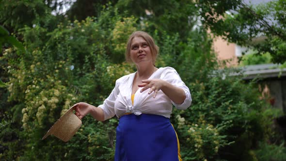 Plussize Charming Woman Taking Off Straw Hat Spinning in Slow Motion Looking Up Enjoying Summer Day alt