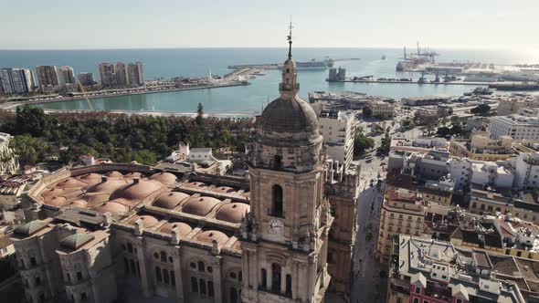 Malaga Cathedral of Incarnation with port in background, Spain. Aerial circling