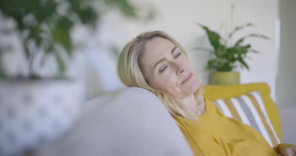 Mature woman relaxing on couch alt