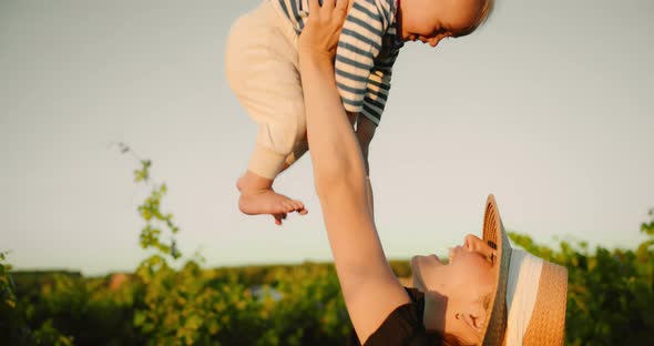 Young Mother Have Fun with Her Cute Little Baby Son in French Provence Vineyard During Summer Sunset alt