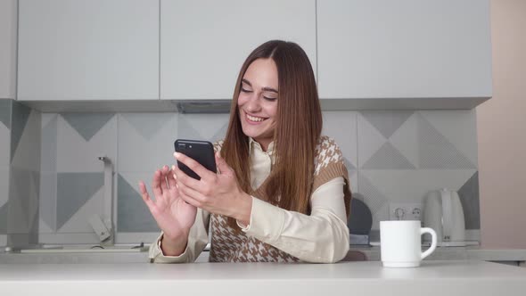 Young Pretty Woman of Caucasian European Appearance Using Mobile Phone and is Emotionally Happy alt
