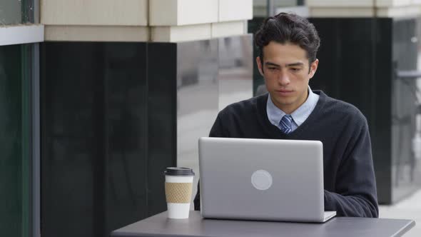 Young businessman using laptop computer at outdoor cafe