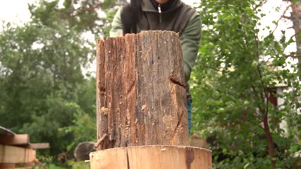 Splitting a wooden log in half with an axe. (slomo) alt