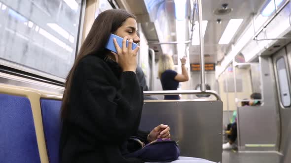 Girl talking on the phone on commuting by metro