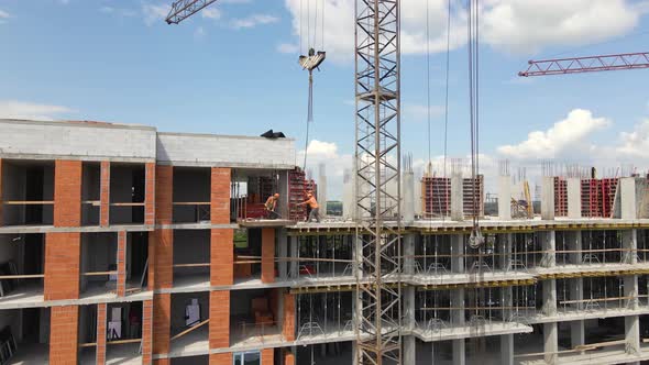 Tower Cranes and Professional Workers at High Concrete Residential Building Under Construction alt