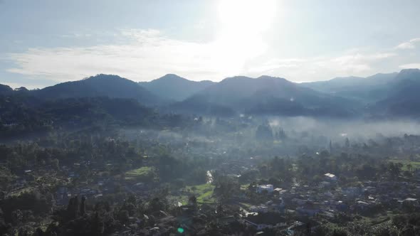 Cinematic aerial view of foggy valley with mountains in the morning