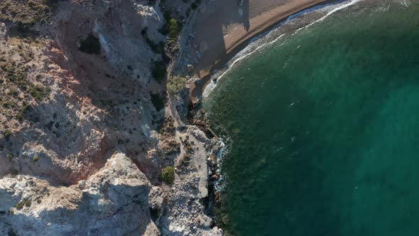 Slow Overhead Top Down Aerial Along Generic Coast and Beach with Turquoise Water and Waves Crashing alt