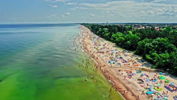 Flying above crowded beach on Baltic beach, aerial view alt