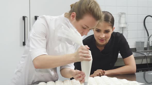 Gorgeous Female Pastry Baker Watching Her Colleague Making Marshmallows alt
