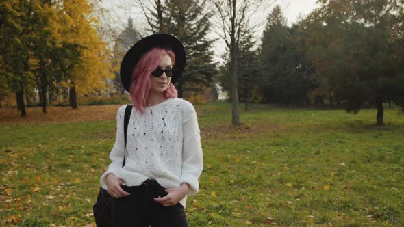 Portrait of Effective Female Hipster in Hat and Sunglasses Poses at Camera alt