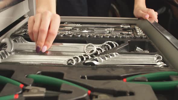 Female Mechanic Taking Instruments From Toolbox in Repair Garage alt