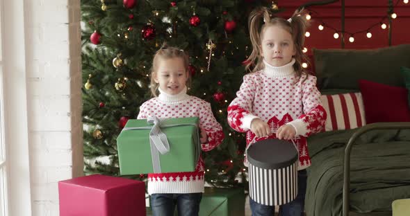 Little Girls Hold Their Christmas Presents and Smiles