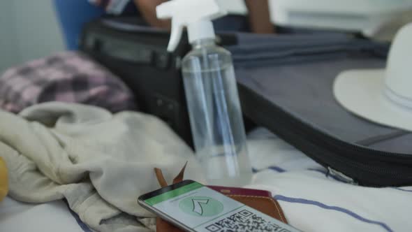 Animation of african american senior woman packing suitcase for travel alt