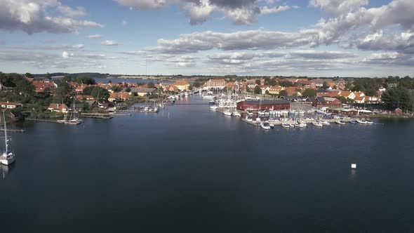 Flying Low Over The Water And Raises High Up Over Port And City