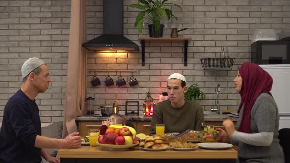 Eid Mubarak. Ramadan. Religious Asian Muslim Family. Father, mother and children. The Iftar alt