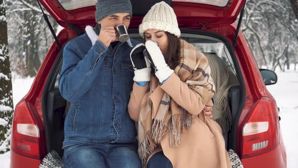 Tea party in car trunk - loving couple sits in car trunk in Valentine's day