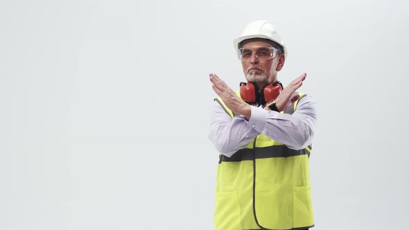 Adult engineer in working uniform shows the cross with hands and shakes head negatively alt