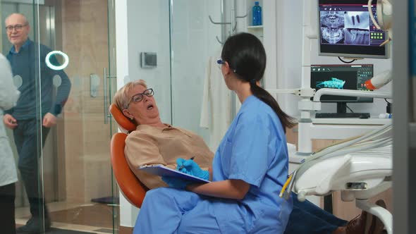Patient with Tooth Pain Explaining Dental Problem To Nurse alt