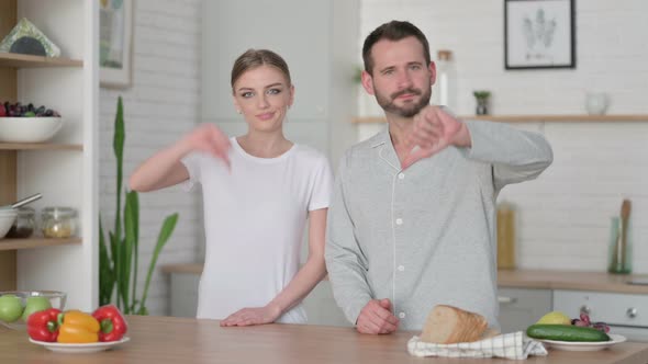 Woman and Man Showing Thumbs Down Sign alt