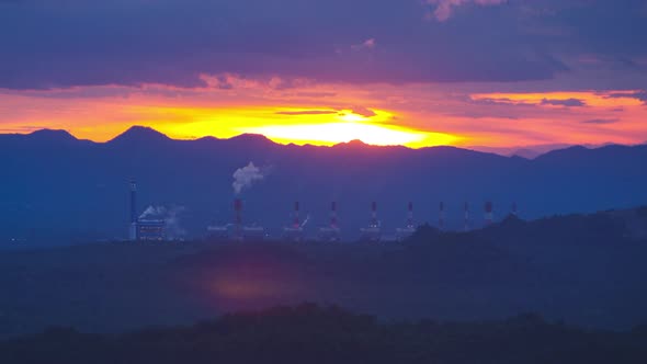 Aerial view over coal-fired power plant at sunset  with smoke from cooling,