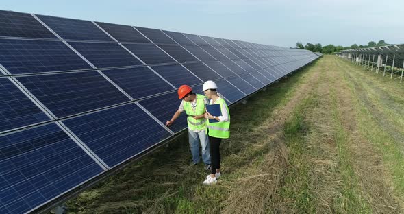 Two Solar Power Engineers Working on a Solar Farm