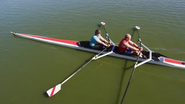 Senior caucasian man and woman rowing boat on a river alt