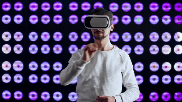 Man in a Virtual Reality Helmet Draws with His Hand in the Computer World