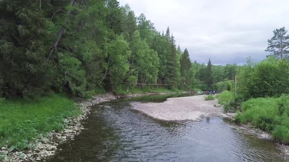 Picturesque forest river and old wooden bridge alt