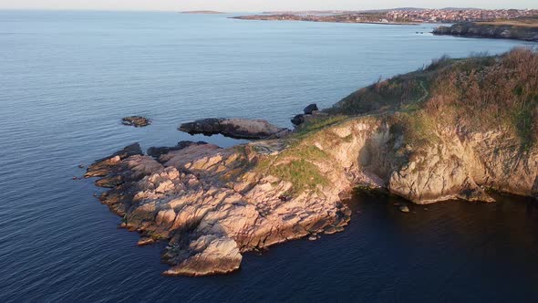 Shore with Grass and Hotels in the Distance Surrounded By the Black Sea Under a Clear Sky alt