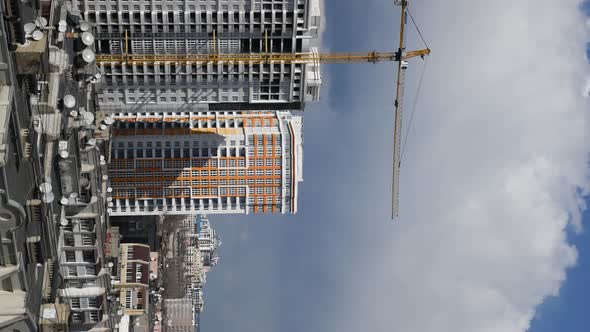 Unfinished Building with Construction Crane Boom Time Lapse of Clouds in Sky