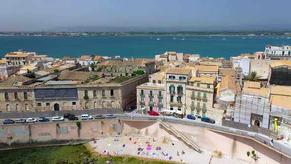 Revealing drone shot of Syracuse coastline, historic city on the Italian island of Sicily with the I alt