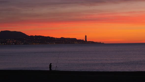 Silhouette of a fisherman in a beautiful sunrise over the Mediterranean sea. Malagueta Beach alt