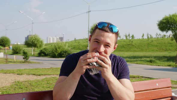A Man Biting Hamburger with Great Appetite alt