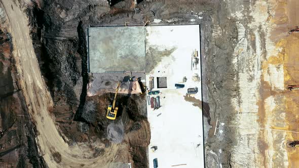 Aerial shot of heavy machinery on construction site or quarry alt