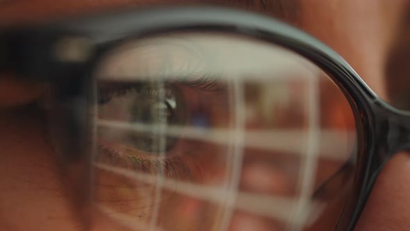 Businesswoman working at night, reflections in eyeglasses. alt