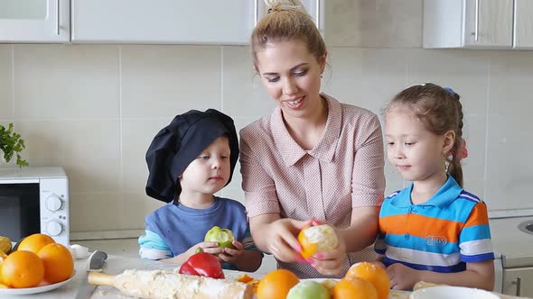 Little Chefs Learn To Cook. Mother with Children in the Kitchen.