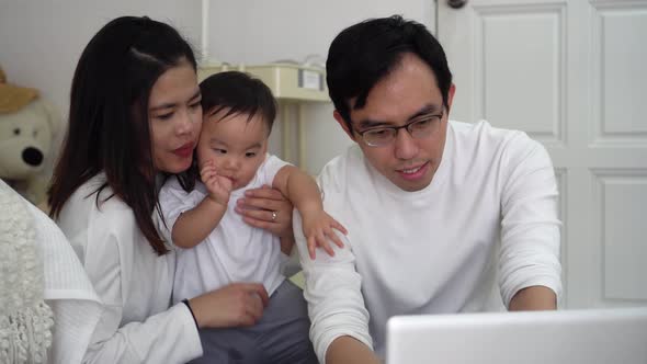 Father Working Using Laptop with His Wife and Cute Boy While Sitting on Floor in Cozy Room at Home alt